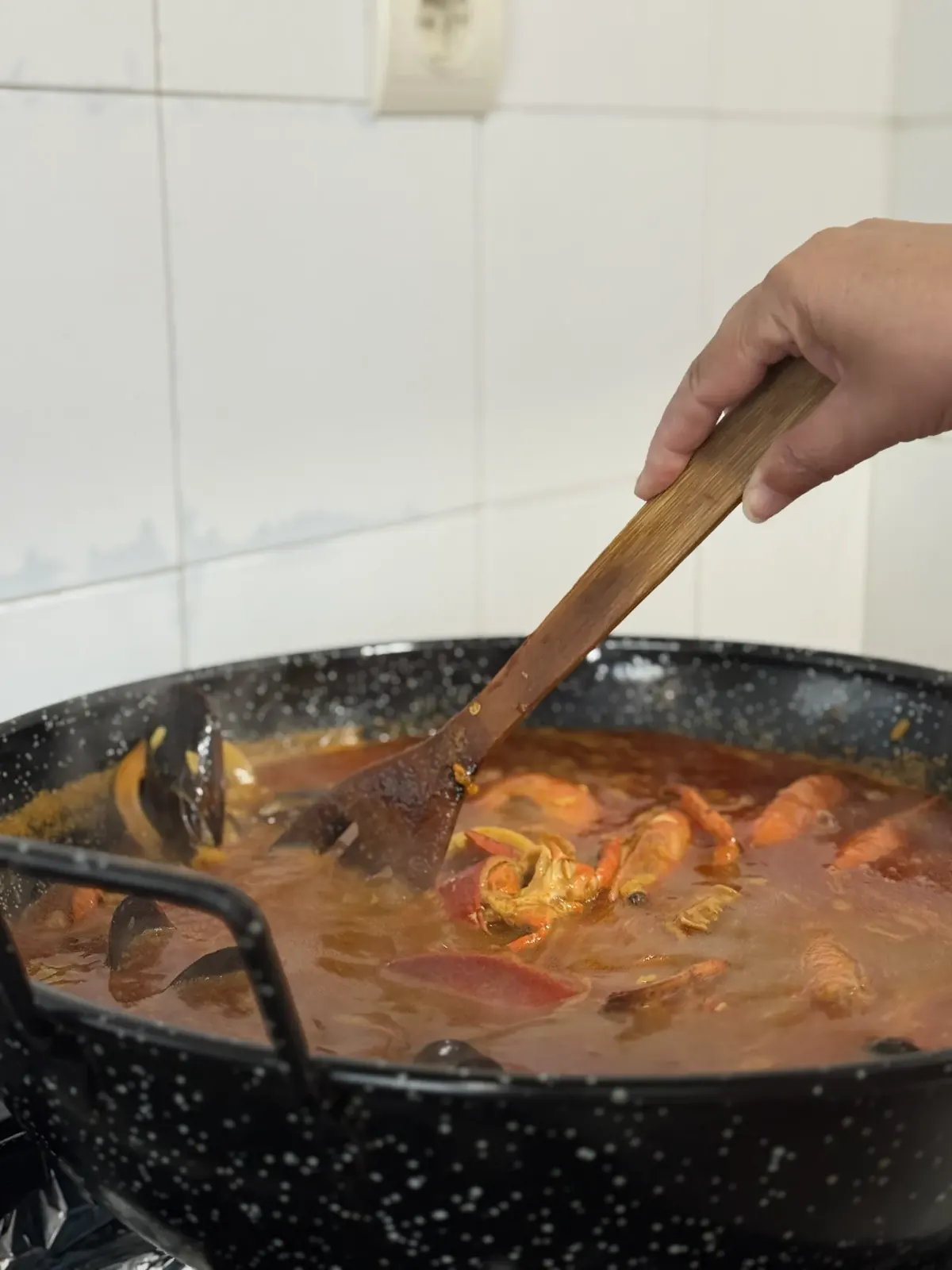 Removiendo el gazpacho en la paellera