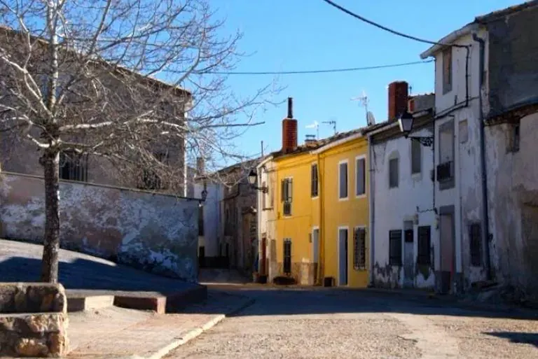 Calle de Olmeda de la Cuesta con una casa pintada de amarillo